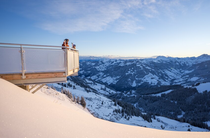 Zwei Personen stehen auf einer Aussichtsplattform und blicken über ein verschneites Tal mit Bergen und Wäldern | © Dorfgasteiner Bergbahnen AG
