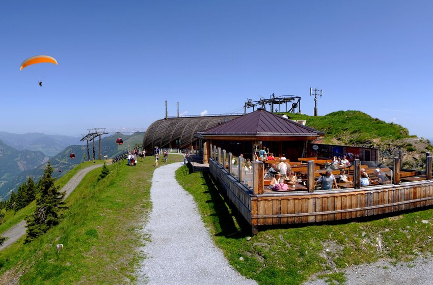 Paragliders over Großarltal near mountain station with visitors on sun terrace and panoramic view | © Grossarler Bergbahnen GmbH & Co KG