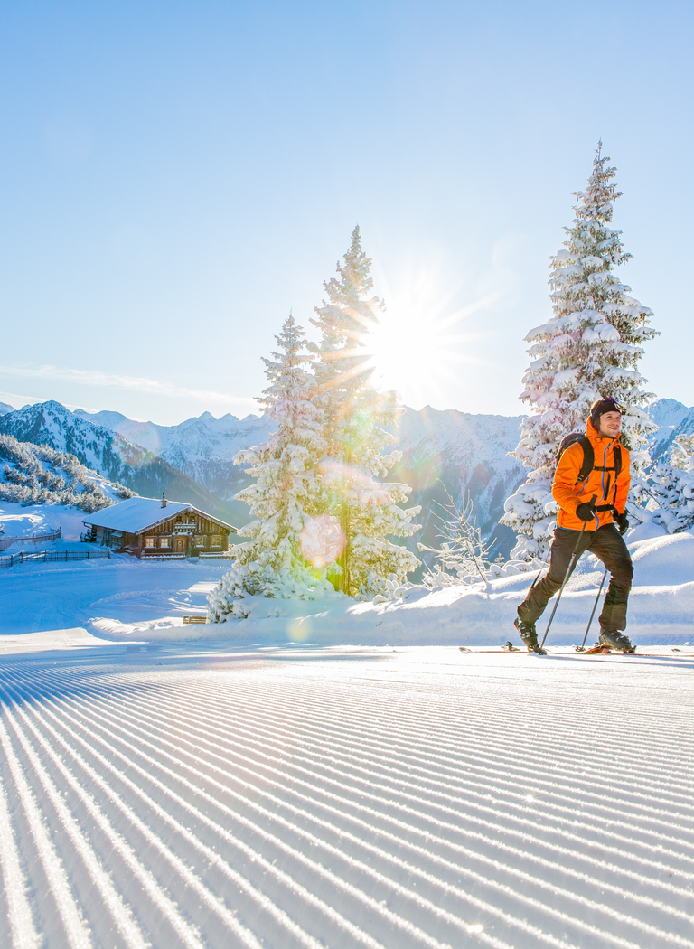 Two ski tourers in sunshine on a groomed slope at Hochwurzen mountain | © Ski amadé GmbH