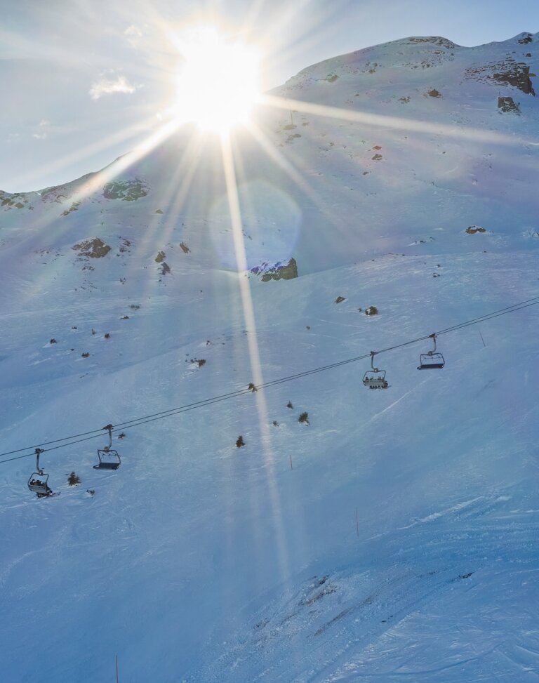 Sessellift fährt bei tiefstehender Sonne über eine verschneite Piste mit Funpar | © Gasteiner Bergbahnen AG